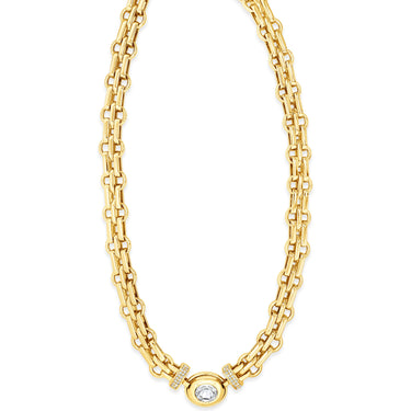 Gold chain necklace with a central gemstone on a white background
