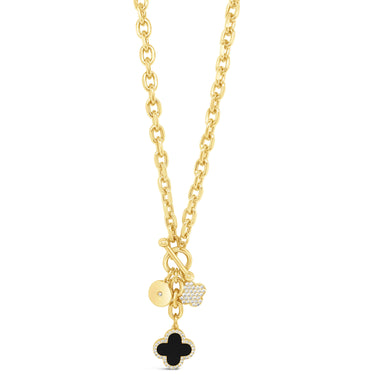 Gold necklace with black clover charm on a white background