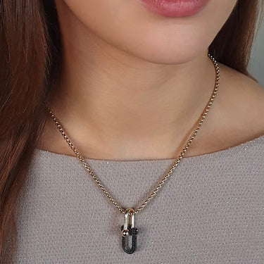 Necklace with a pendant worn by a person against a neutral background