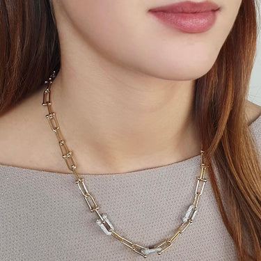 Necklace with gold and silver chain worn by a person