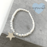 Bracelet with star charm on a gray surface, featuring the brand 'Engravable'.