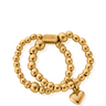 Gold beaded bracelet with a heart charm on a white background