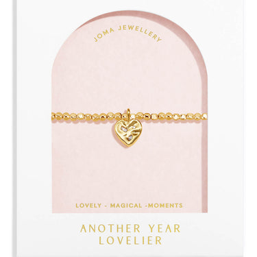 Gold bracelet with heart charm on a Joma Jewellery display card.