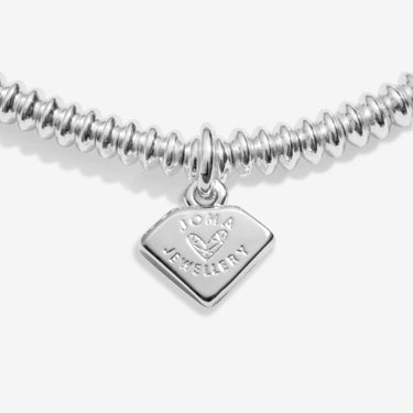 Silver bracelet with a heart-shaped tag on a white background