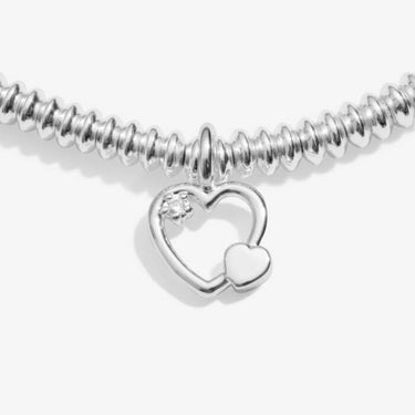 Silver bracelet with a heart-shaped charm and lab diamond on a white background
