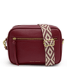 Red handbag with a patterned strap on a white background