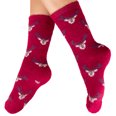 Red socks with reindeer pattern worn by a person on a white background