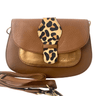 Brown leather handbag with a leopard print strap on a white background