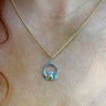 Gold necklace with a claddagh pendant on a person's neck