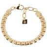 A gold-toned metal link bracelet with a lobster clasp and a small hanging square tag engraved with the brand name 'ZAG'.