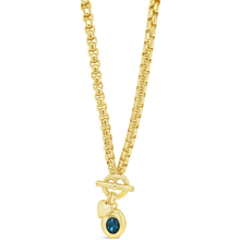 Gold necklace with a blue gemstone pendant on a white background