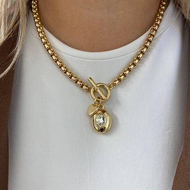 Gold chain necklace with a pendant on a white background