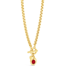 Gold necklace with a red gemstone pendant on a white background