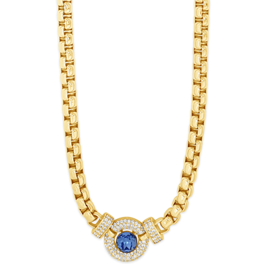 Gold necklace with a blue gemstone and clear stones on a white background