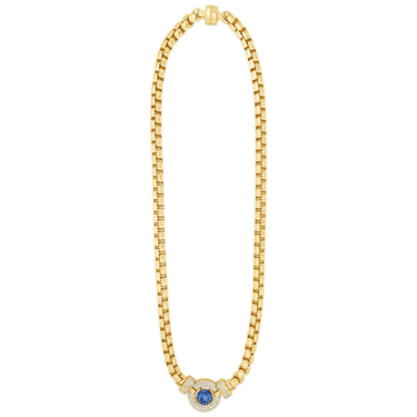 Gold necklace with a blue gemstone on a white background