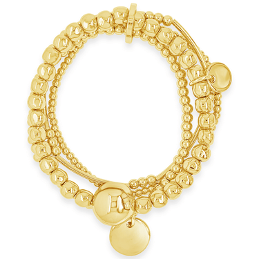 Gold bracelet with beads and circular charms on a white background