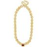 Gold chain necklace with a red gemstone on a white background