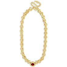 Gold chain necklace with a red gemstone on a white background