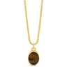 A gold chain necklace with an oval pendant featuring a brown tiger's eye stone in a gold bezel, shown against a plain white background.