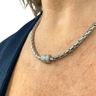 Silver chain necklace with a clasp worn by a person
