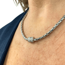 Silver chain necklace with a clasp worn by a person