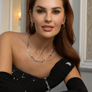 Woman wearing a silver necklace with a black top indoors