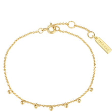 A delicate gold chain anklet with small bead accents, a lobster clasp, and an adjustable extender chain featuring a rectangular tag engraved with the brand name 'ANJA HAE'.