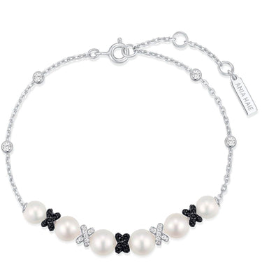 Pearl bracelet with black and white butterfly charms on a white background
