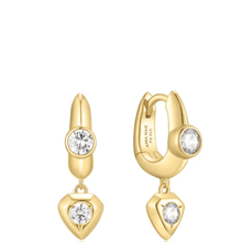 Gold hoop earrings with heart-shaped drops and clear gemstones on a white background