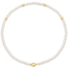 A delicate pearl necklace with small white pearls and gold-toned accents, including a central gold clasp, displayed on a clean white background.
