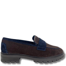 A dark brown suede penny loafer with navy blue accents on the strap, lining, and heel, featuring a chunky dark gray lug sole, shown against a plain white background.
