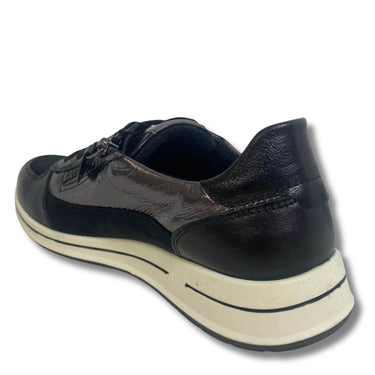 A black leather low-top sneaker shown from a three-quarters rear angle, featuring a textured black heel, black laces, and a thick cream-colored midsole and outsole.