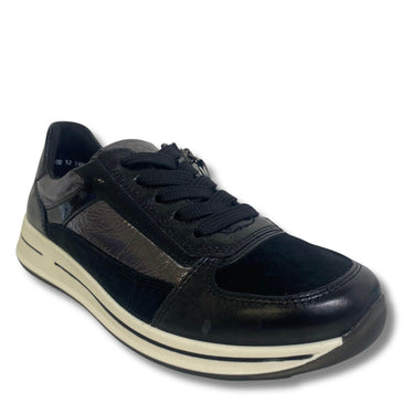 A black low-top sneaker with mixed leather and textured synthetic panels, black laces, and a thick cream-colored midsole, shown on a white background.