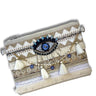 Decorative clutch bag with eye design and tassels on a white background