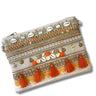 Decorative clutch bag with tassels and embellishments on a white background