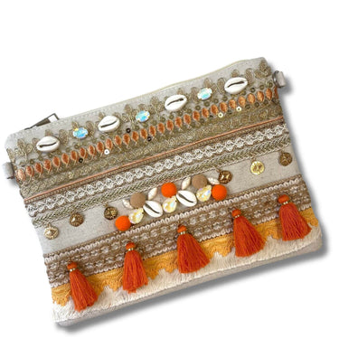 Decorative clutch bag with tassels and embellishments on a white background