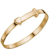 A polished gold-plated bangle bracelet with a small heart-shaped charm on a plain white background.