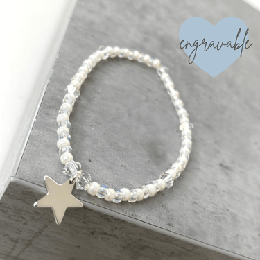Bracelet with star charm on a gray surface, featuring the brand 'Engravable'.