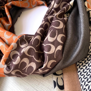 Close-up of patterned fabric with orange, brown, and beige colors.