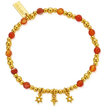 Gold beaded bracelet with orange beads and star charms on a white background