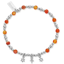 Bracelet with orange beads and silver star charms on a white background