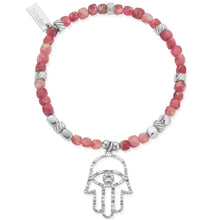 Bracelet with pink beads and silver Hamsa hand charm on a white background
