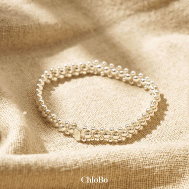 silver bracelet on a beige fabric background