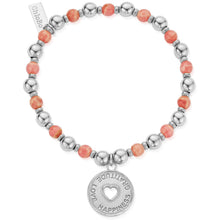 Bracelet with coral beads and a silver charm on a white background