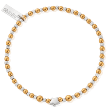 Bracelet with gold and silver beads and a star charm on a white background
