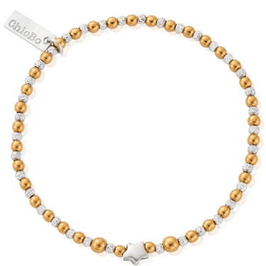 Bracelet with gold and silver beads and a star charm on a white background
