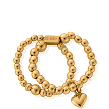 Gold beaded bracelet with a heart charm on a white background