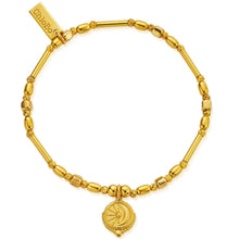 Gold bracelet with a decorative charm on a white background