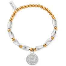 Bracelet with gold and silver beads and a medallion on a white background
