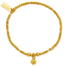 Gold bracelet with a sun charm on a white background